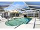 Relaxing in-ground swimming pool surrounded by a spacious patio with comfortable lounge furniture and shade umbrellas at 888 Guild Dr, Venice, FL 34285