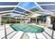 Inviting in-ground swimming pool inside of lanai with ample seating and patio space for outdoor enjoyment at 888 Guild Dr, Venice, FL 34285
