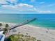 Pier stretching into the ocean, surrounded by beach and palm trees at 1104 Riviera St, Venice, FL 34285