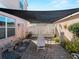 Backyard patio area shaded by covering, lounge chair, and white picket fence at 12468 Shimmering Oak Cir, Venice, FL 34293