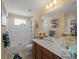 Bathroom features a single sink, framed mirror, bathtub and shower with themed decor at 12468 Shimmering Oak Cir, Venice, FL 34293