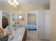 Bathroom featuring a double sink, mirrors, tile floor, and open view to the bedroom at 12468 Shimmering Oak Cir, Venice, FL 34293
