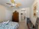 Bedroom featuring ceiling fan, closet, wood dresser, and surf-themed decorations at 12468 Shimmering Oak Cir, Venice, FL 34293