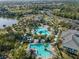 An aerial view shows a resort style pool, water slide, and leisure area amidst lush tropical landscaping at 12468 Shimmering Oak Cir, Venice, FL 34293