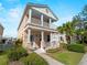 Charming two-story home featuring a double porch, well-manicured lawn, and tropical landscaping at 12468 Shimmering Oak Cir, Venice, FL 34293