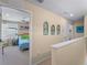 Hallway leads to a bedroom with soft lighting, a ceiling fan, and a comfortable bed at 12468 Shimmering Oak Cir, Venice, FL 34293