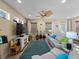 Spacious living room with a large TV, guitars, comfortable seating, and ample natural light at 12468 Shimmering Oak Cir, Venice, FL 34293