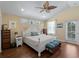 Bright main bedroom featuring a ceiling fan, wood floors, an ensuite bathroom, and a private balcony at 12468 Shimmering Oak Cir, Venice, FL 34293