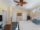 Bright main bedroom featuring a ceiling fan, wood floors, an ensuite bathroom, and a private balcony at 12468 Shimmering Oak Cir, Venice, FL 34293