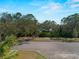 Street view showing the lush landscaping and trees surrounding the property with water in the distance at 12468 Shimmering Oak Cir, Venice, FL 34293