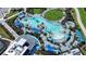 An aerial view of the community pool shows its resort-style design with blue umbrellas and lounge chairs at 12580 Galapagos Ct # 107, Venice, FL 34293