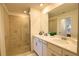 Well-lit bathroom with double vanity, tiled shower, and modern fixtures at 12580 Galapagos Ct # 107, Venice, FL 34293