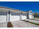 Row of garages with beautifully landscaped brick driveway and condo buildings in the background at 12580 Galapagos Ct # 107, Venice, FL 34293