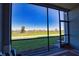 View from the lanai of the golf course on a bright sunny day, featuring comfortable seating and an outdoor rug at 12580 Galapagos Ct # 107, Venice, FL 34293