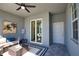 This is a beautiful screened patio with a ceiling fan, a cozy couch, and an outdoor rug and table at 12580 Galapagos Ct # 107, Venice, FL 34293
