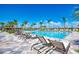 Beautiful community pool area with comfortable lounge chairs, palm trees, and clear blue skies at 12744 Oriago St, Venice, FL 34293