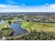 Expansive aerial view of the community, featuring a well-manicured golf course, serene lakes, and lush surroundings at 1298 Highland Greens Dr, Venice, FL 34285