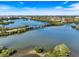 Scenic aerial view of a tranquil lake, showcasing a charming bridge and lush green surroundings at 1298 Highland Greens Dr, Venice, FL 34285