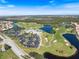 Beautiful aerial view of the golf course, clubhouse and surrounding community, showcasing the lush landscaping and serene lakes at 1298 Highland Greens Dr, Venice, FL 34285