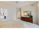 Cozy bedroom with dresser, carpeted floors, and an open doorway to the Primary bath at 1298 Highland Greens Dr, Venice, FL 34285