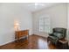 Inviting bedroom with hardwood floors, featuring an accent chair and a window with shutters at 1298 Highland Greens Dr, Venice, FL 34285