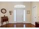 Welcoming foyer with a white front door, transom window, hardwood floors, and a classic desk at 1298 Highland Greens Dr, Venice, FL 34285