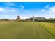 Scenic golf course view with green grass, blue sky, and a clubhouse in the background at 1298 Highland Greens Dr, Venice, FL 34285