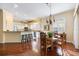 Open-concept kitchen with white cabinets, breakfast bar, and stainless steel appliances, seamlessly connecting to dining area at 1298 Highland Greens Dr, Venice, FL 34285