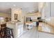 Bright kitchen with white cabinetry, granite countertops, stainless steel appliances, and a breakfast bar at 1298 Highland Greens Dr, Venice, FL 34285