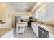 Well-lit kitchen featuring white cabinetry, stainless steel appliances, granite countertops, and functional center island at 1298 Highland Greens Dr, Venice, FL 34285
