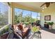 Inviting screened lanai featuring comfortable seating with lush green outdoor views and a ceiling fan at 1298 Highland Greens Dr, Venice, FL 34285