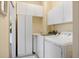 Well-equipped laundry room with modern appliances, sink, and ample storage cabinets at 1298 Highland Greens Dr, Venice, FL 34285