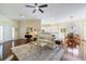 Bright, open living room with hardwood floors, ceiling fan, and comfortable seating flowing to dining area at 1298 Highland Greens Dr, Venice, FL 34285