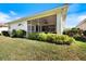Back exterior view showcasing the screened porch and well-maintained lawn at 1298 Highland Greens Dr, Venice, FL 34285