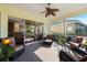Inviting screened porch with comfortable seating, ceiling fan, and serene outdoor views at 1298 Highland Greens Dr, Venice, FL 34285