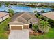 An aerial view of a single-Gathering home overlooking a large lake with surrounding homes and landscaping at 13238 Famiglia Dr, Venice, FL 34293