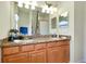 Bathroom showing a double sink vanity with granite countertop and sconce lighting at 13238 Famiglia Dr, Venice, FL 34293