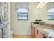 Bright bathroom showcasing a sink with granite counters and leafy window treatments at 13238 Famiglia Dr, Venice, FL 34293