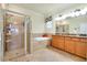 Bathroom boasting a walk-in shower, a tub, and a double-sink vanity at 13238 Famiglia Dr, Venice, FL 34293