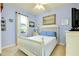 Cozy bedroom featuring a white bed frame, blue accent pillows, and soft natural light at 13238 Famiglia Dr, Venice, FL 34293