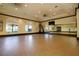 Spacious fitness room with cork floor, mirrors, and large windows offering natural light for exercise and wellness activities at 13238 Famiglia Dr, Venice, FL 34293