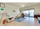 Bright living room with sliding glass doors leading to an outdoor patio with seating at 13238 Famiglia Dr, Venice, FL 34293