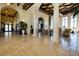A grand lobby with travertine floors, columns, and plenty of natural light at 13238 Famiglia Dr, Venice, FL 34293