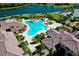 Aerial view of a resort-style pool, clubhouse, and a lake in a luxurious community at 13238 Famiglia Dr, Venice, FL 34293