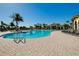 Community pool with lounge chairs and palm trees surrounding the deck at 13238 Famiglia Dr, Venice, FL 34293