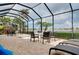 Enclosed pool patio with brick flooring, seating, spa and lake views at 13238 Famiglia Dr, Venice, FL 34293
