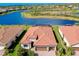 A gorgeous aerial view of a meticulously landscaped home with a red tile roof and a tranquil lake in the backyard at 13730 Vancanza, Venice, FL 34293