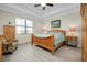 Comfortable bedroom with a tray ceiling, wood furniture, and light wood laminate flooring at 13730 Vancanza, Venice, FL 34293