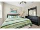 Bedroom with ceiling fan, beach themed decor, and a full dresser with mirror at 13730 Vancanza, Venice, FL 34293