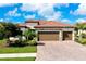 Beautiful home with a three-car garage, well-maintained landscaping, and a brick driveway at 13730 Vancanza, Venice, FL 34293